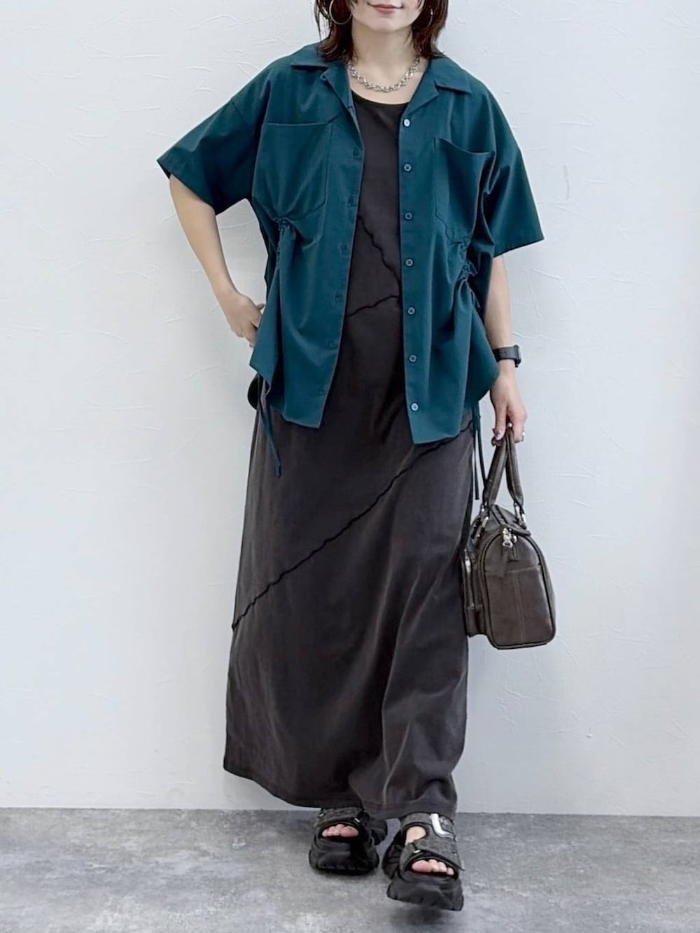 ブラック系のワンピース、グレー系のショルダーバッグ、グリーン系のシャツ/ブラウスを着用したレディースの春コーディネートの3枚目の写真