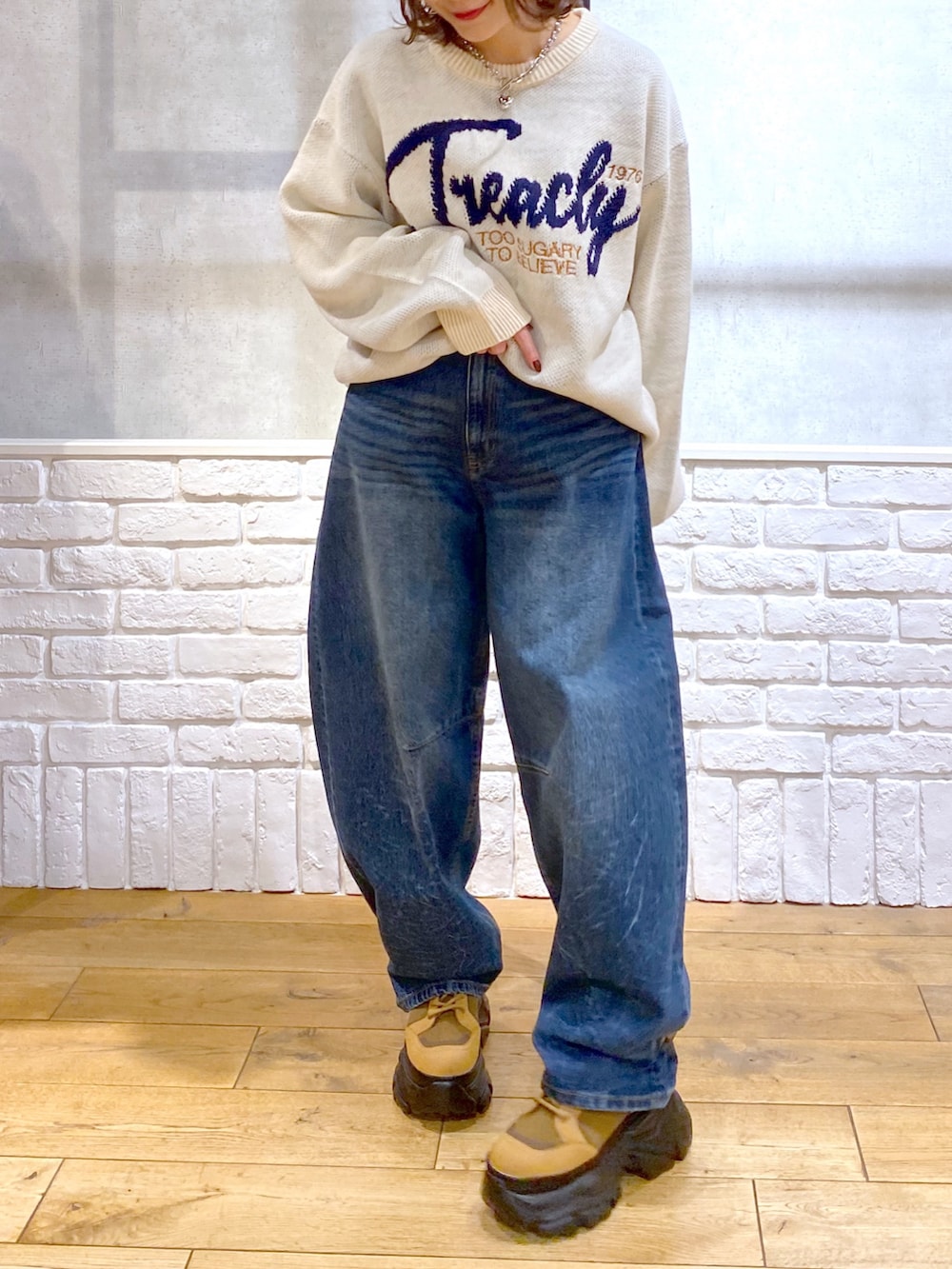ホワイト系のニット/セーター、ブルー系のデニムパンツ、ブラウン系のブーツを着用したレディースの冬コーディネートの3枚目の写真
