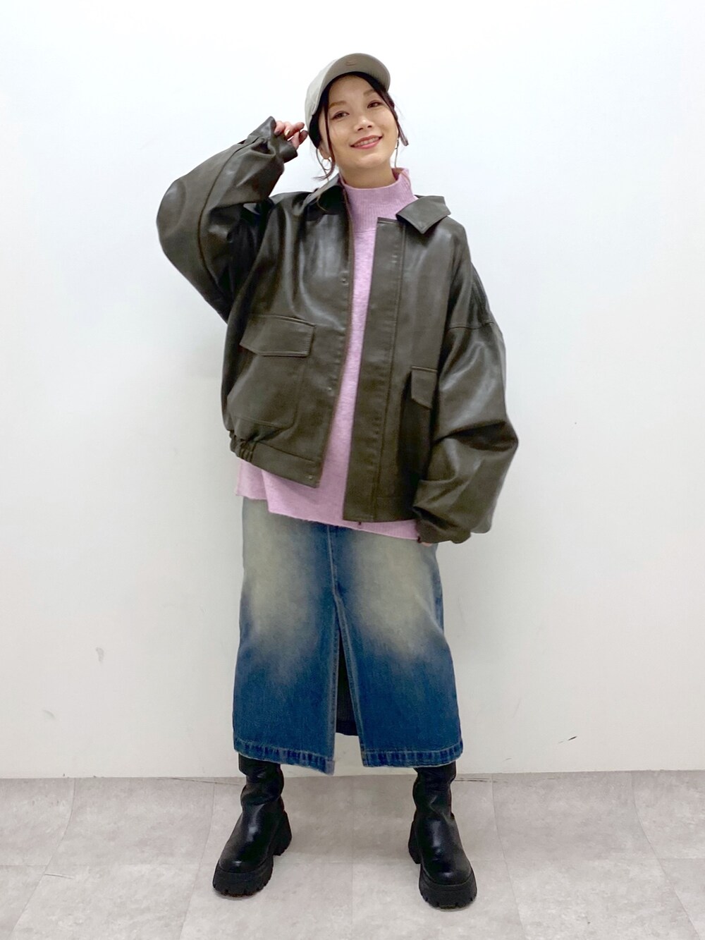 レッド系のニット/セーター、ブルー系のスカート、ブラック系のブーツを着用したレディースの秋コーディネートの2枚目の写真