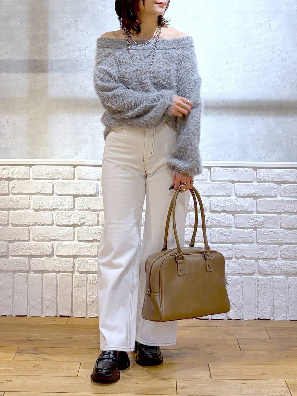 ベージュ系のボストンバッグ、グリーン系のモッズコート、ブラック系のローファーを着用したレディースの冬コーディネートの3枚目の写真