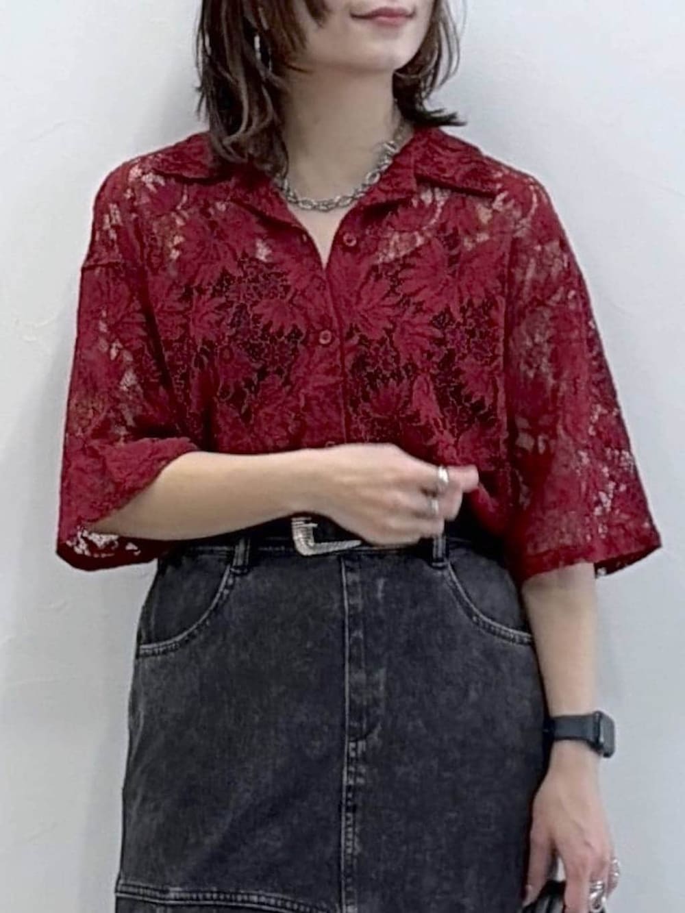 ブラック系のスニーカー、レッド系のシャツ/ブラウス、ブラック系のデニムスカートを着用したレディースの春コーディネートの2枚目の写真