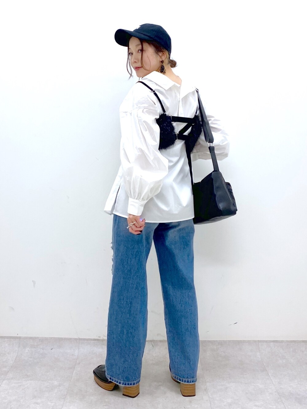 ブルー系のデニムパンツ、ホワイト系のシャツ/ブラウス、ブラック系のベストを着用したレディースの秋コーディネートの6枚目の写真