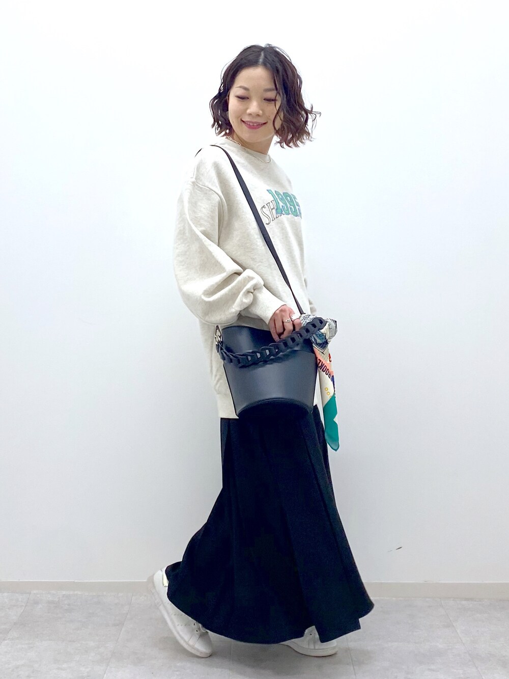 ベージュ系のスカート、ベージュ系のスウェット、ブラック系のショルダーバッグを着用したレディースの春コーディネートの3枚目の写真