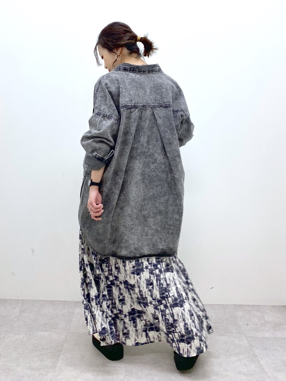 ブラック系のトップス、ブラック系のスカート、ホワイト系のトップスを着用したレディースの春コーディネートの3枚目の写真