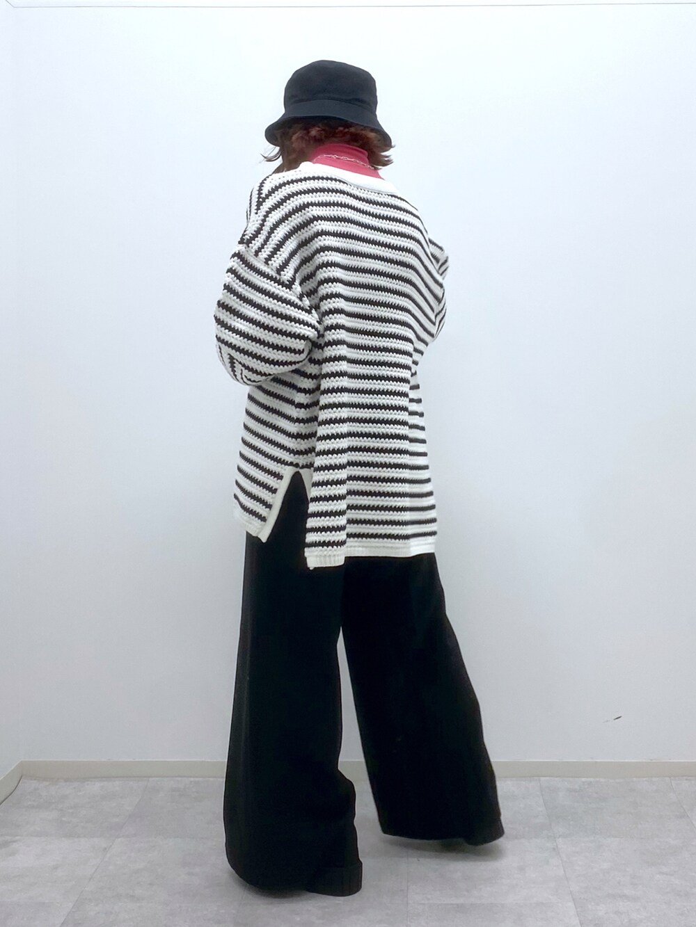 ホワイト系のニット/セーター、ピンク系のTシャツ/カットソー、ブラック系のスラックスを着用したレディースの春コーディネートの3枚目の写真