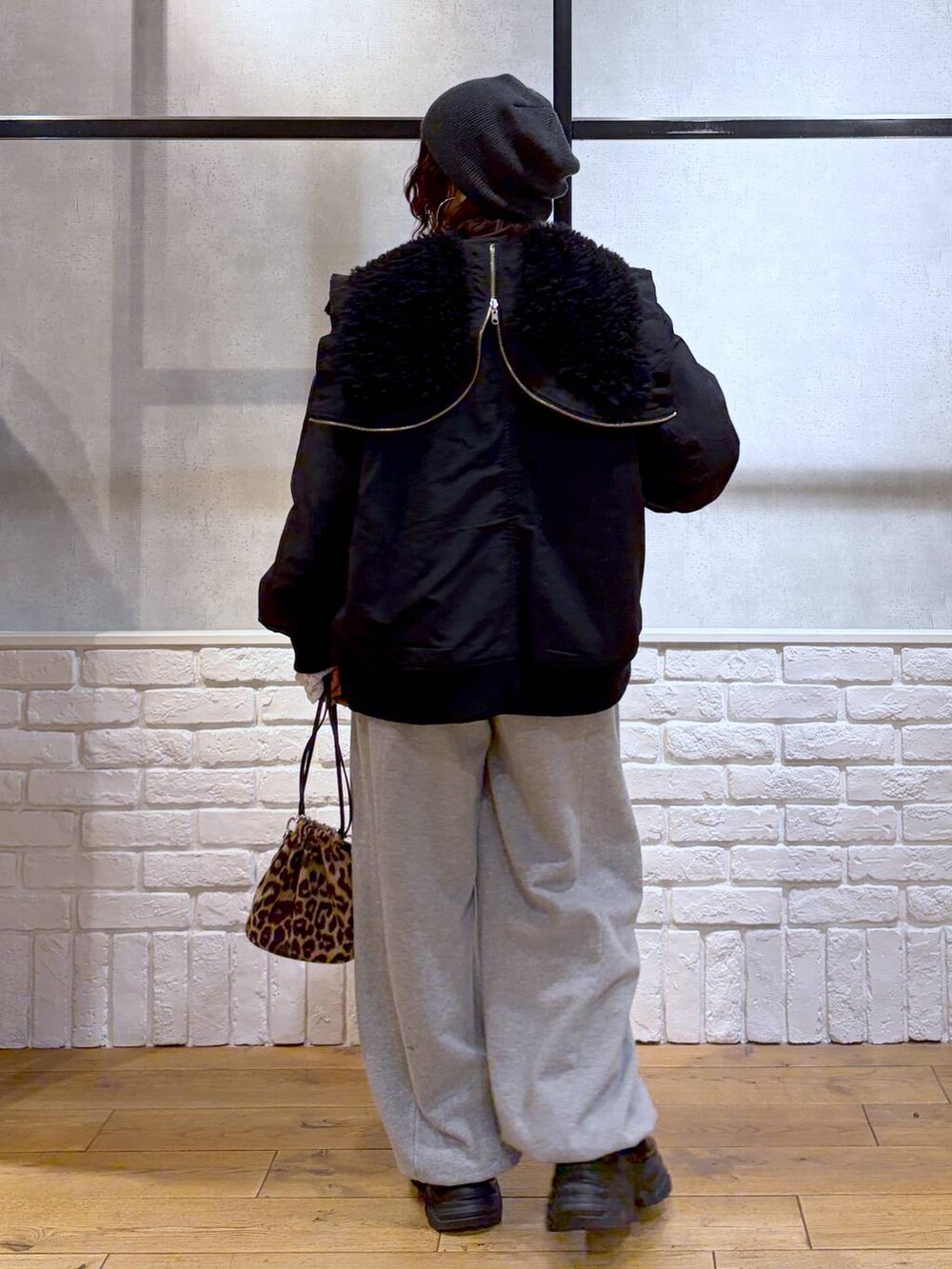 ブラック系のブーツ、グレー系のスウェットパンツ、ブラック系のブルゾンを着用したレディースの冬コーディネートの6枚目の写真