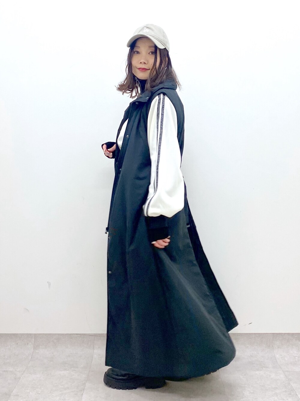 ブラック系のベスト、ブラック系のブーツ、ホワイト系のジャージを着用したレディースの秋コーディネートの7枚目の写真