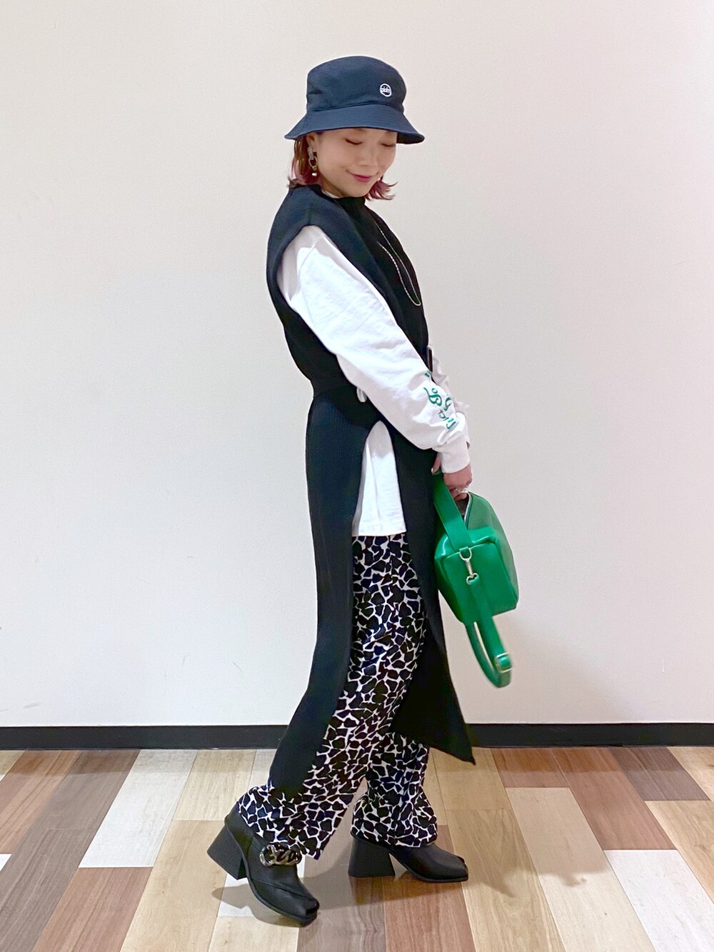 ブラック系のパンプス、ブラック系のワンピース、ホワイト系のTシャツ/カットソーを着用したレディースの冬コーディネートの3枚目の写真