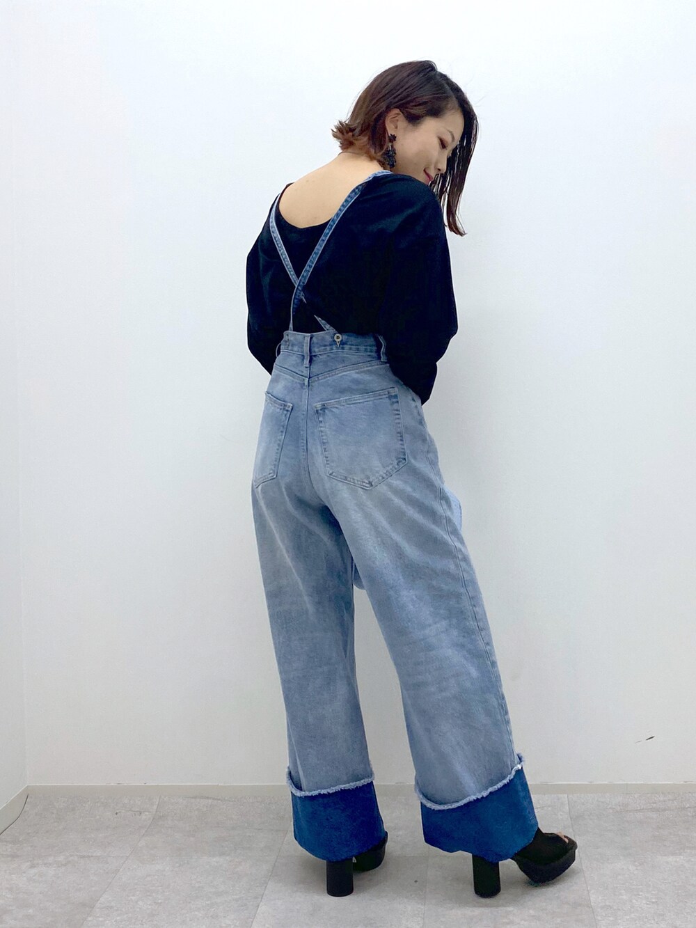 ブルー系のデニムパンツ、ブラック系のTシャツ/カットソー、ブルー系のショルダーバッグを着用したレディースの春コーディネートの4枚目の写真