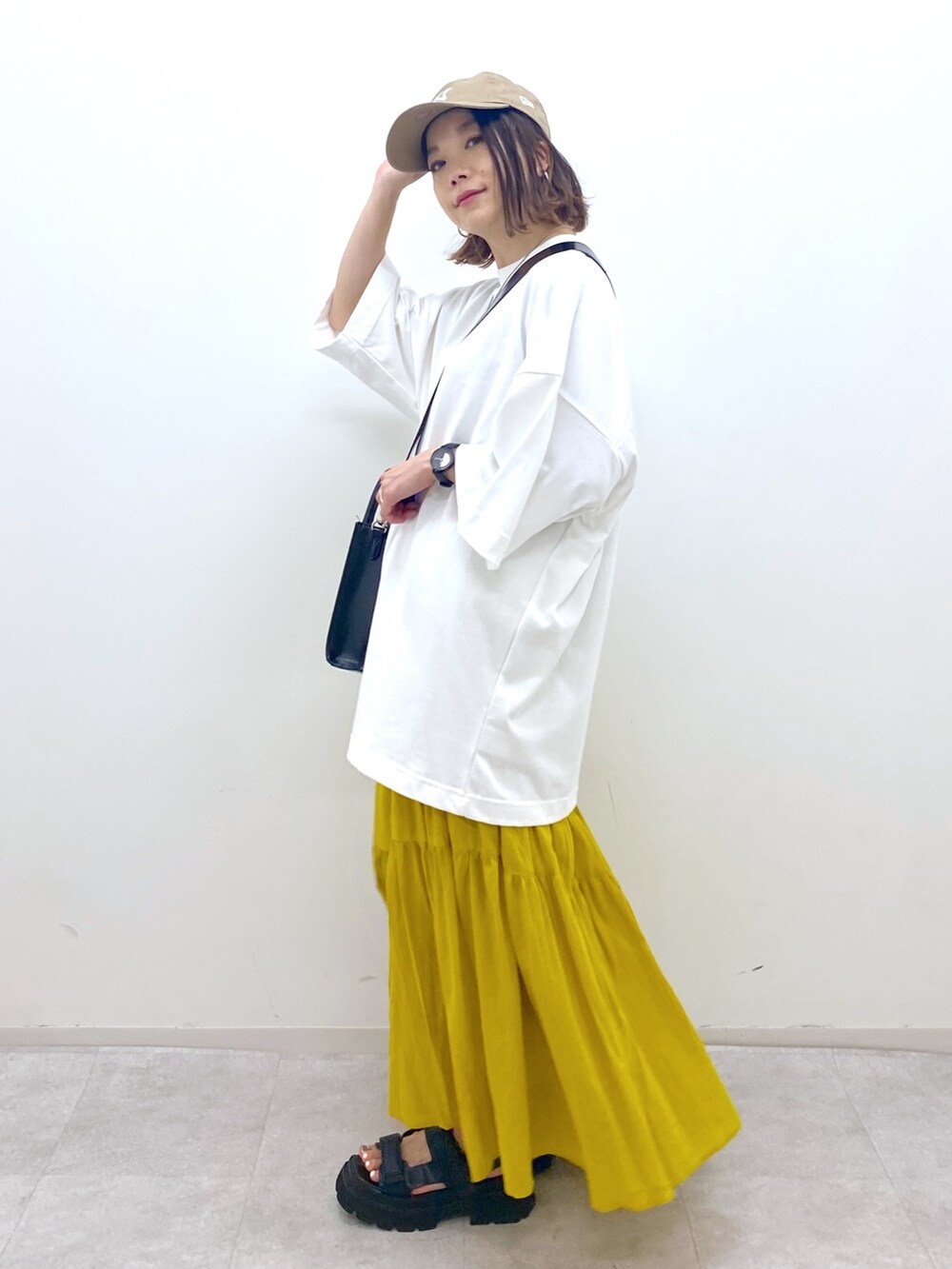 ホワイト系のTシャツ/カットソー、ブラック系のショルダーバッグ、ブラック系のサンダルを着用したレディースの夏コーディネートの4枚目の写真