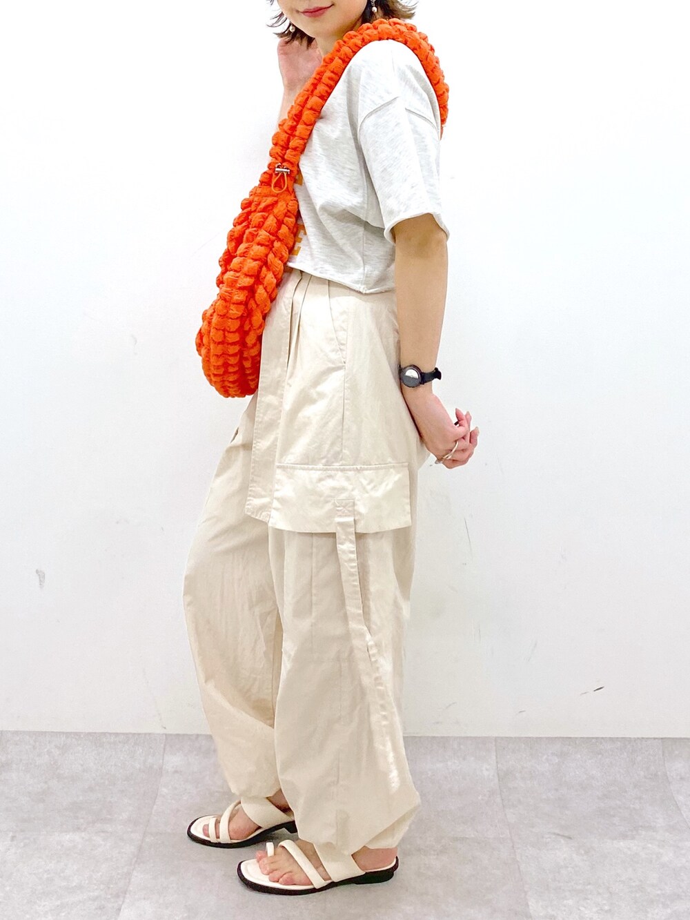 ホワイト系のカーゴパンツ、ホワイト系のサンダル、ベージュ系のTシャツ/カットソーを着用したレディースの春コーディネートの4枚目の写真