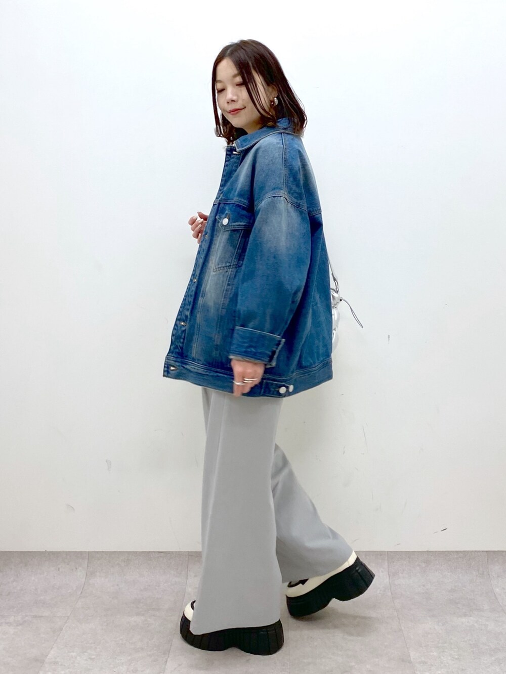 ホワイト系のシャツ/ブラウス、ブルー系のデニムジャケット、ホワイト系のローファーを着用したレディースの冬コーディネートの6枚目の写真