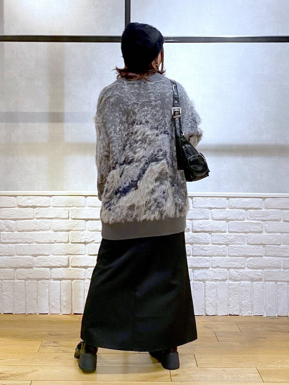 シルバー系のTシャツ/カットソー、ブラック系のブーツ、ブラック系のスカートを着用したレディースの冬コーディネートの6枚目の写真