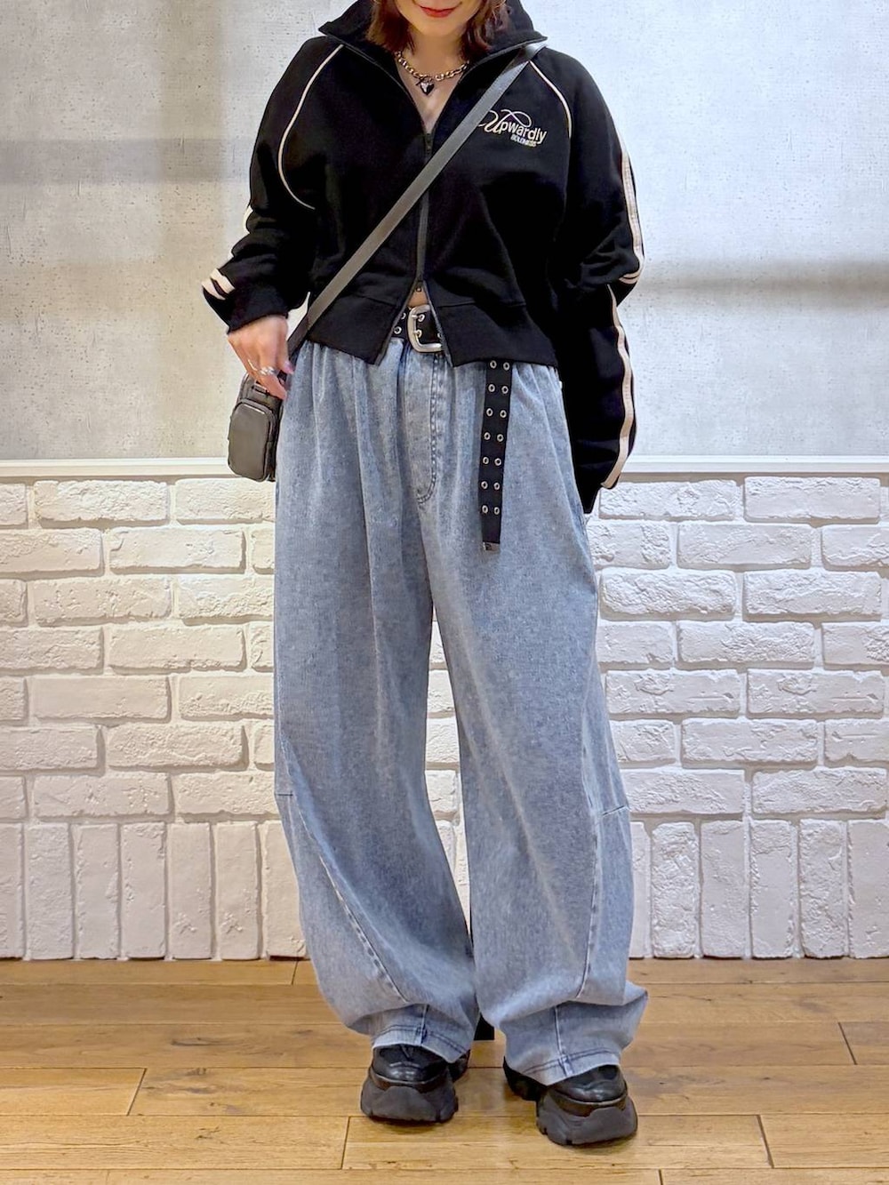 ブラック系のスニーカー、グレー系のショルダーバッグ、ブルー系のデニムパンツを着用したレディースの春コーディネートの3枚目の写真