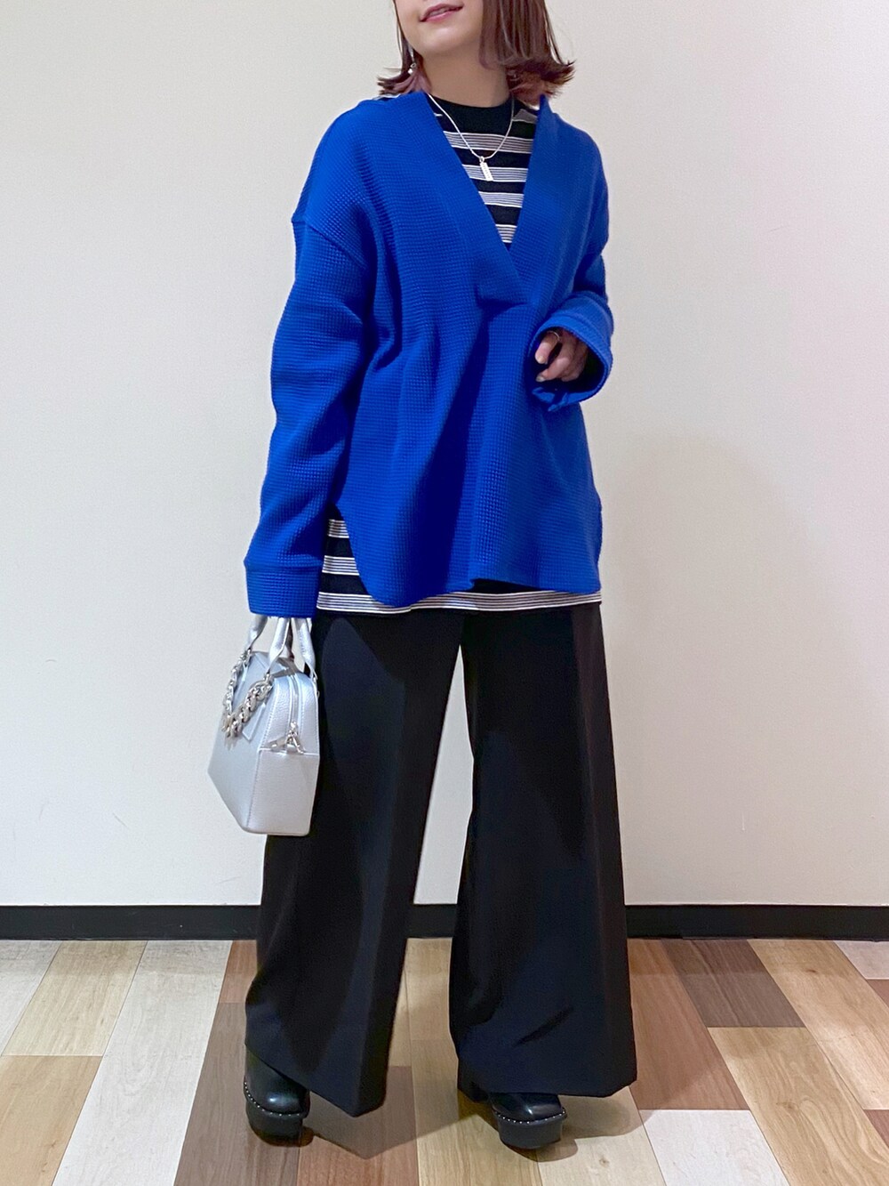 シルバー系のショルダーバッグ、ブラック系のブーツ、ブルー系のTシャツ/カットソーを着用したレディースの冬コーディネートの5枚目の写真