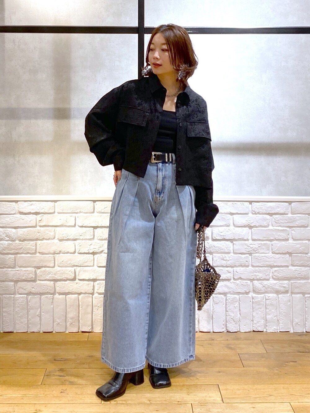 ブラック系のシャツ/ブラウス、ブルー系のデニムパンツ、ブルー系のショルダーバッグを着用したレディースの冬コーディネートの8枚目の写真