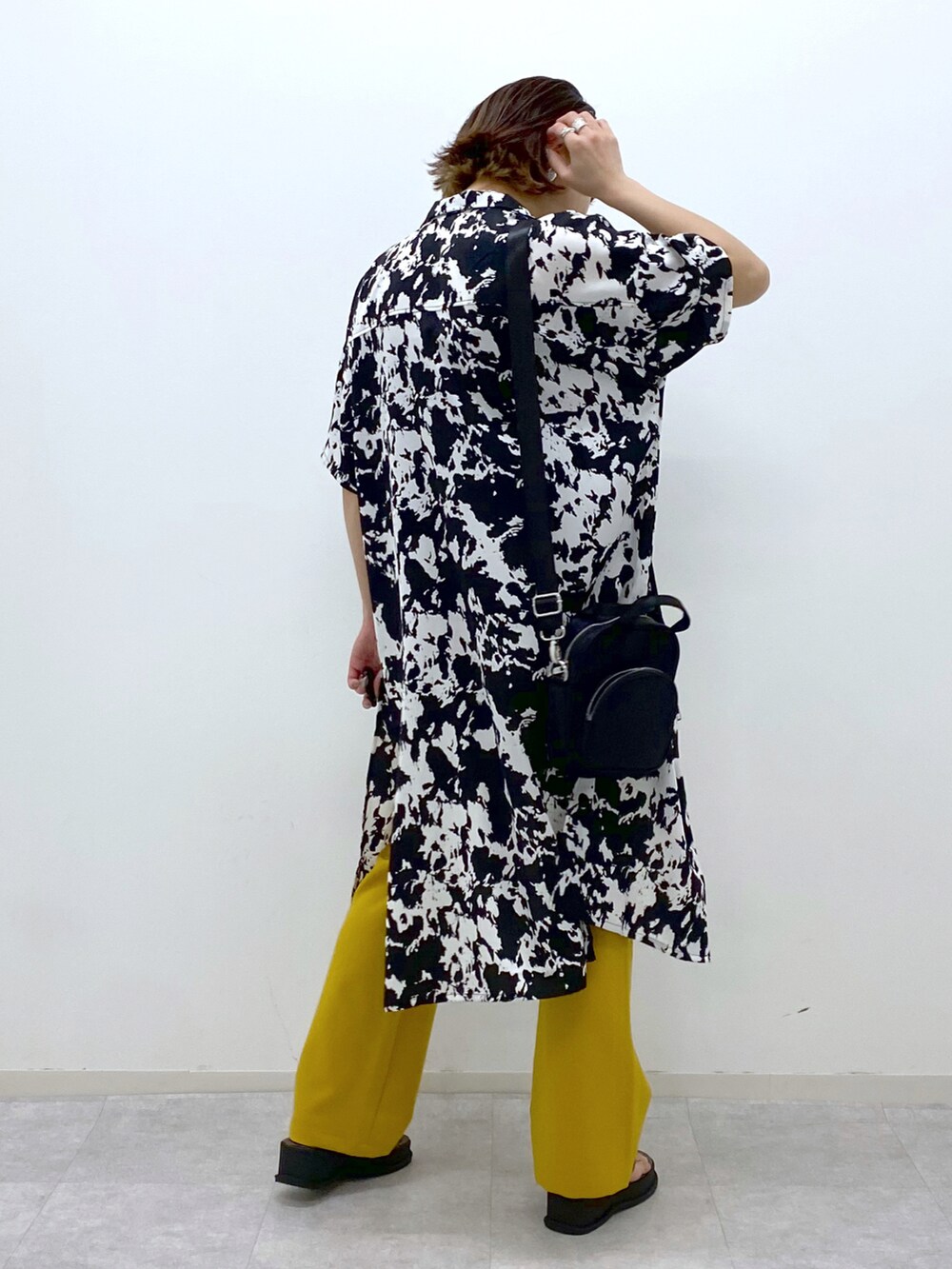 イエロー系のスラックス、その他のサンダル、ブラック系のショルダーバッグを着用したレディースの春コーディネートの4枚目の写真