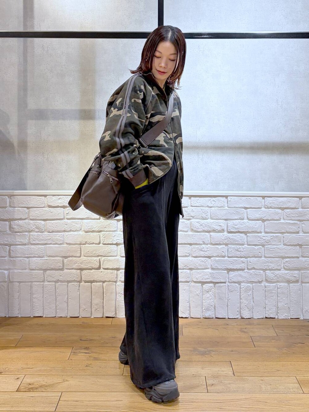 グレー系のスニーカー、ブラウン系のボストンバッグ、イエロー系のニット/セーターを着用したレディースの冬コーディネートの6枚目の写真