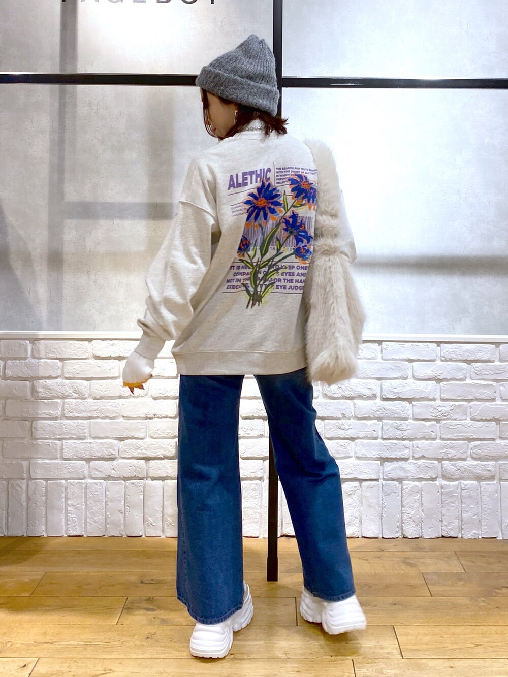 ホワイト系のショルダーバッグ、ブルー系のデニムパンツ、ホワイト系のブーツを着用したレディースの秋コーディネートの7枚目の写真