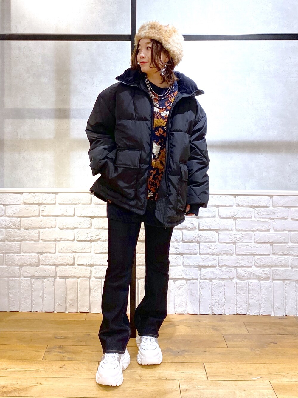 ブルー系のニット/セーター、ブラック系のブルゾン、ブルー系のデニムパンツを着用したレディースの冬コーディネートの9枚目の写真