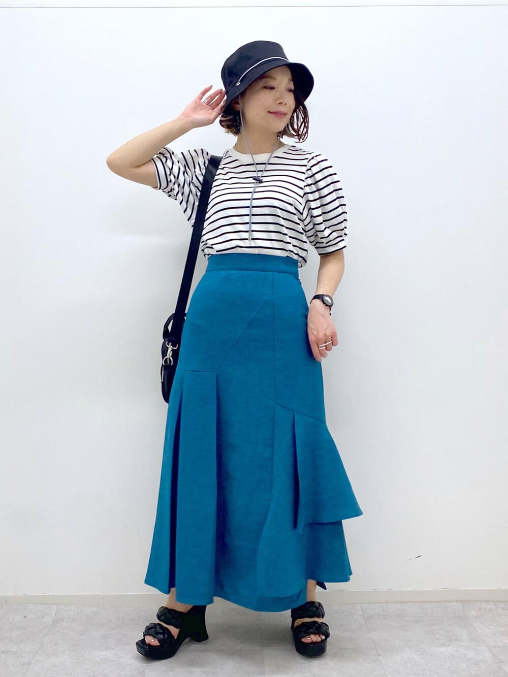 ブルー系のスカート、ブラック系のサンダル、ブラック系のショルダーバッグを着用したレディースの夏コーディネートの5枚目の写真