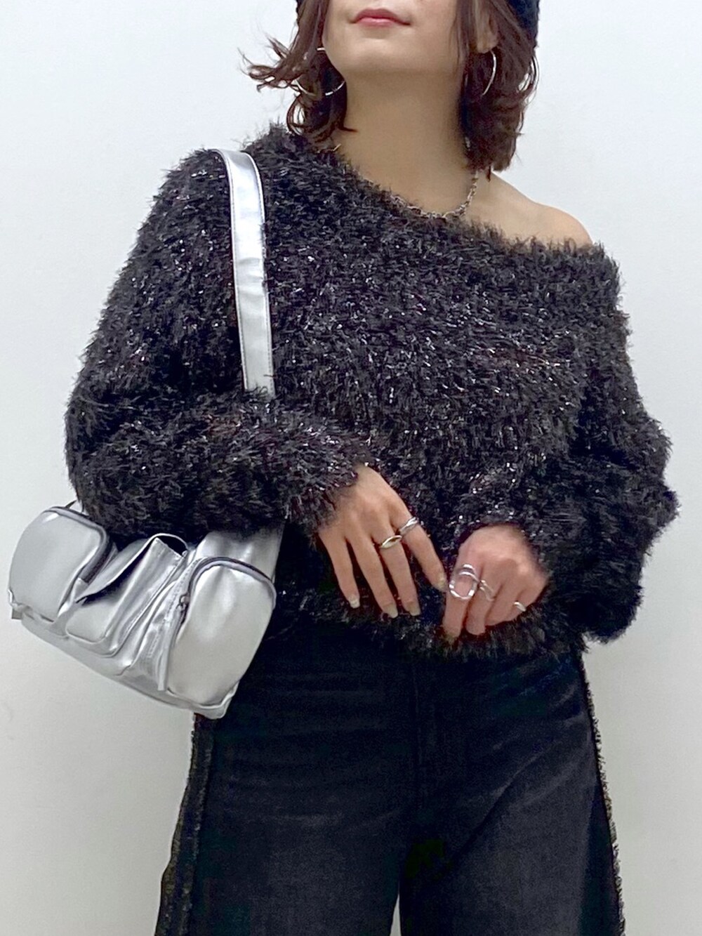 ブラック系のデニムパンツ、シルバー系のパンプス、シルバー系のショルダーバッグを着用したレディースの秋コーディネートの2枚目の写真