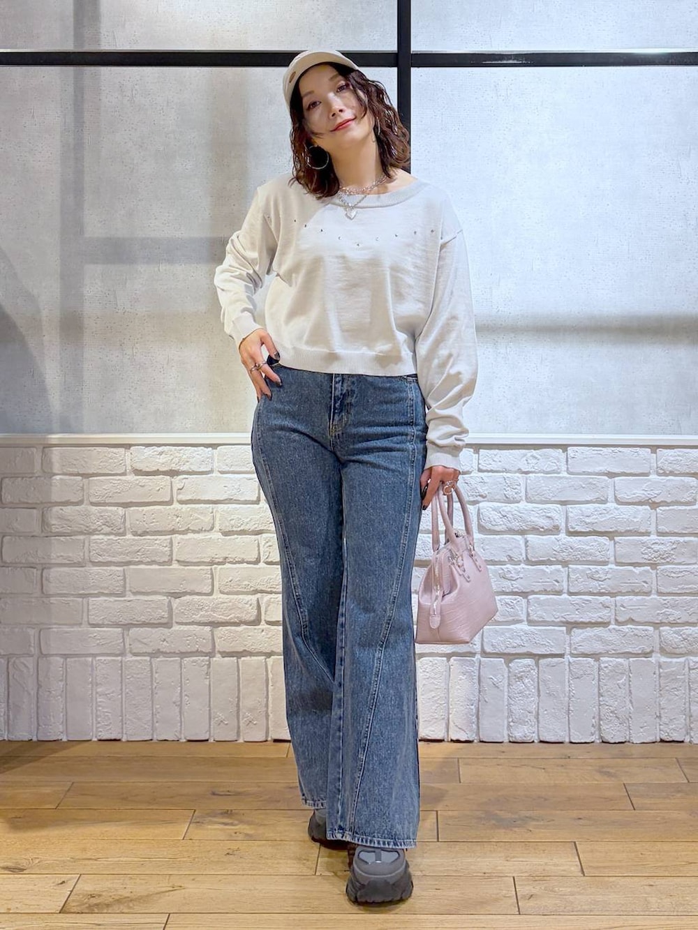 グレー系のスニーカー、ブルー系のデニムパンツ、ピンク系のハンドバッグを着用したレディースの冬コーディネートの9枚目の写真
