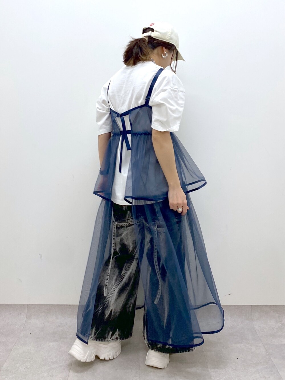 ホワイト系のTシャツ/カットソー、ブルー系のワンピース、ブラック系のデニムパンツを着用したレディースの春コーディネートの6枚目の写真