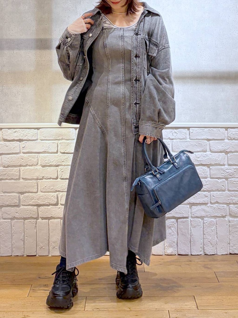 ブラック系のスニーカー、ブルー系のハンドバッグ、ブラック系のブルゾンを着用したレディースの冬コーディネートの2枚目の写真