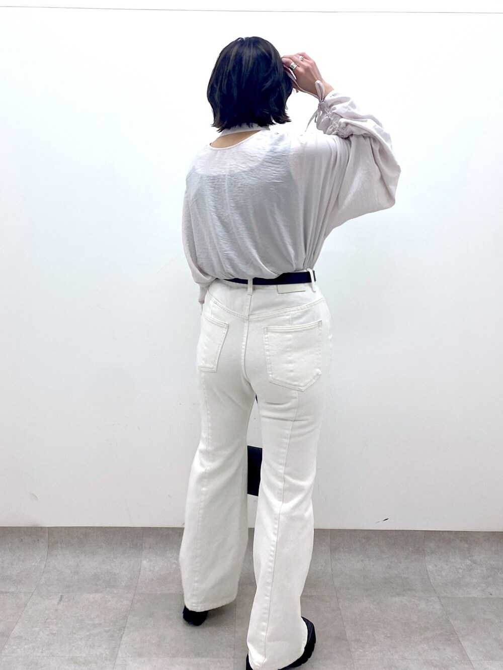 ホワイト系のパンツ、ブラック系のバッグ、ブラック系のローファーを着用したレディースの春コーディネートの3枚目の写真