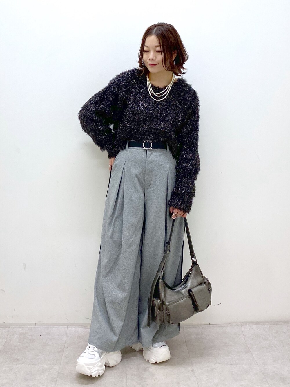 ブラック系のニット/セーター、ブラック系のスラックス、その他のショルダーバッグを着用したレディースの冬コーディネートの4枚目の写真