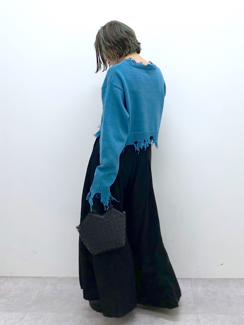 ブラック系のショルダーバッグ、ブラック系のスラックス、ブラック系のブーツを着用したレディースの冬コーディネートの2枚目の写真