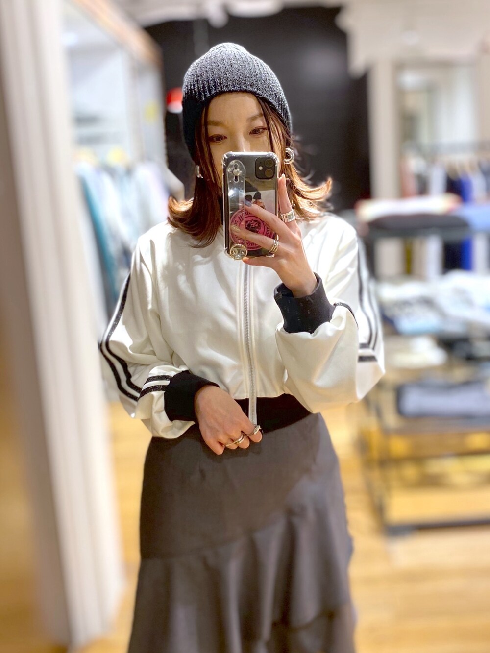 グレー系のスカート、ホワイト系のジャージ、ブラック系のブーツを着用したレディースの冬コーディネートの4枚目の写真