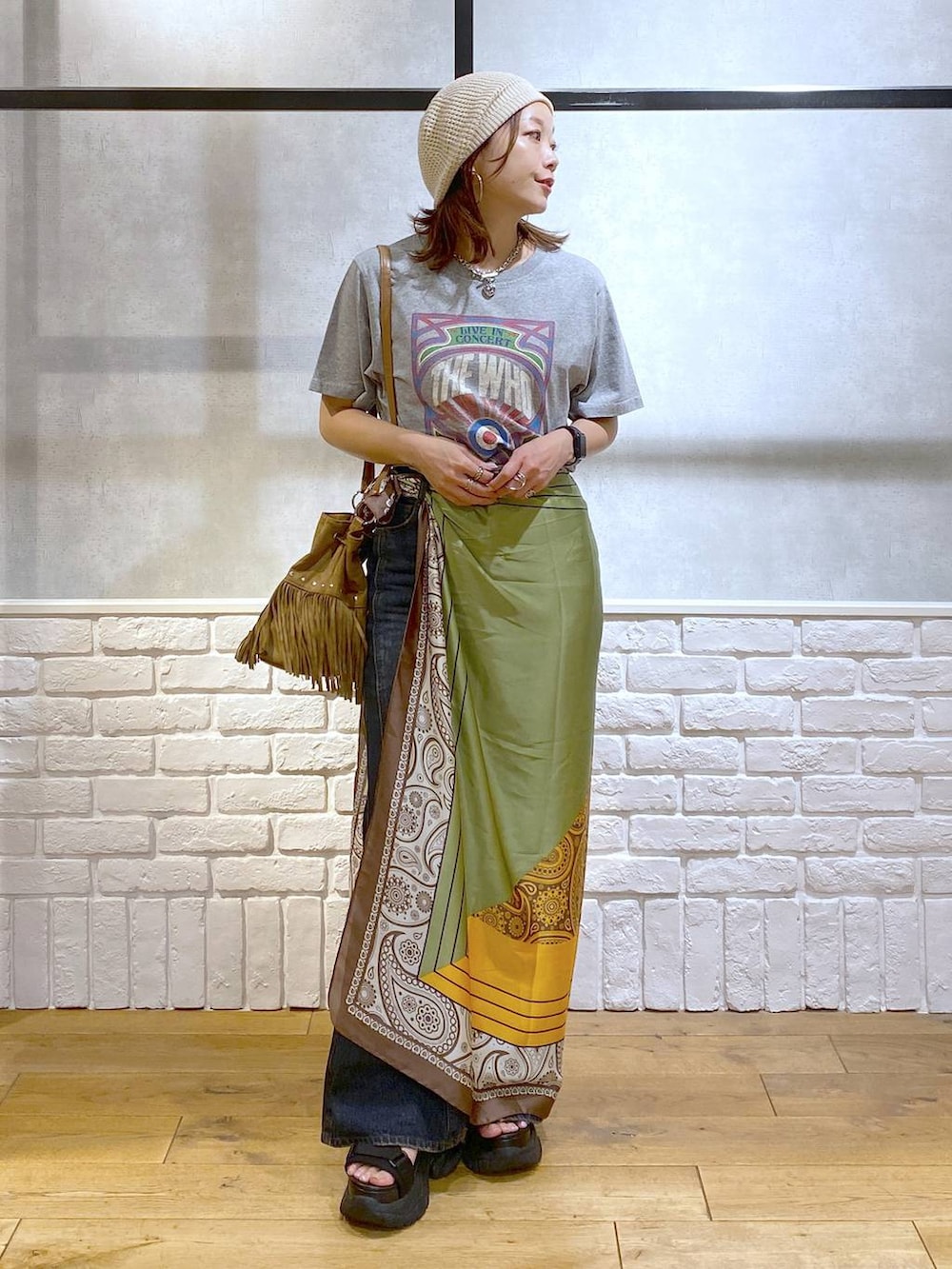 ブラック系のサンダル、ブルー系のデニムパンツ、ベージュ系のショルダーバッグを着用したレディースの夏コーディネートの5枚目の写真