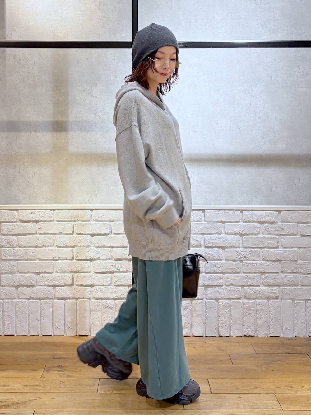 グレー系のスニーカー、グレー系のパーカー、ブラック系のショルダーバッグを着用したレディースの春コーディネートの5枚目の写真