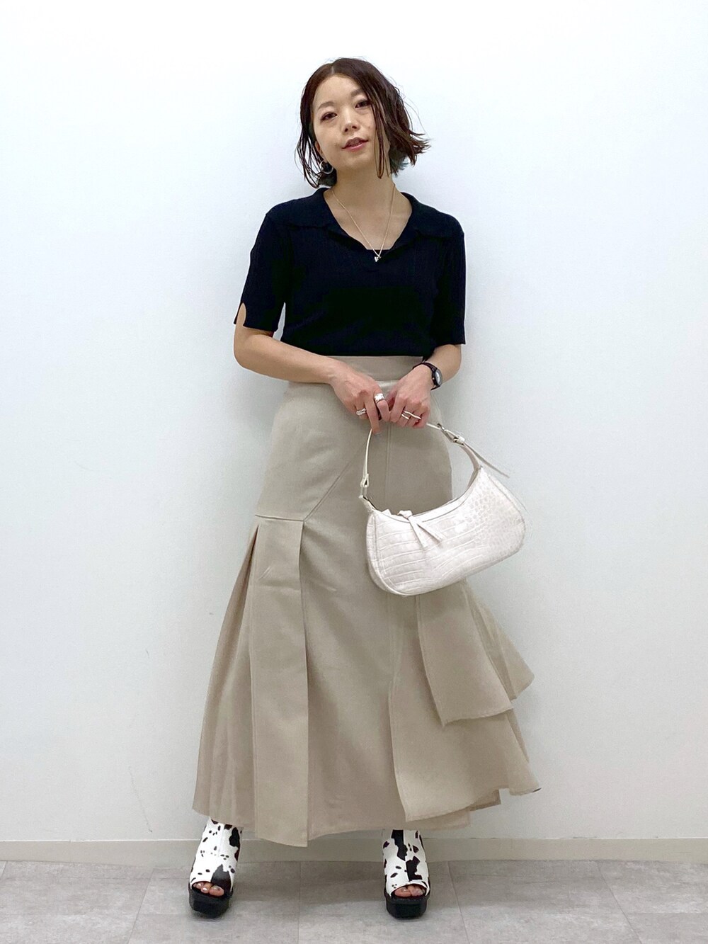 ホワイト系のショルダーバッグ、ベージュ系のスカート、ホワイト系のサンダルを着用したレディースの春コーディネートの5枚目の写真