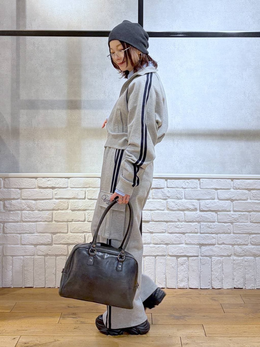 ブラック系のブーツ、ブラック系のボストンバッグ、グレー系のジャージを着用したレディースの冬コーディネートの4枚目の写真