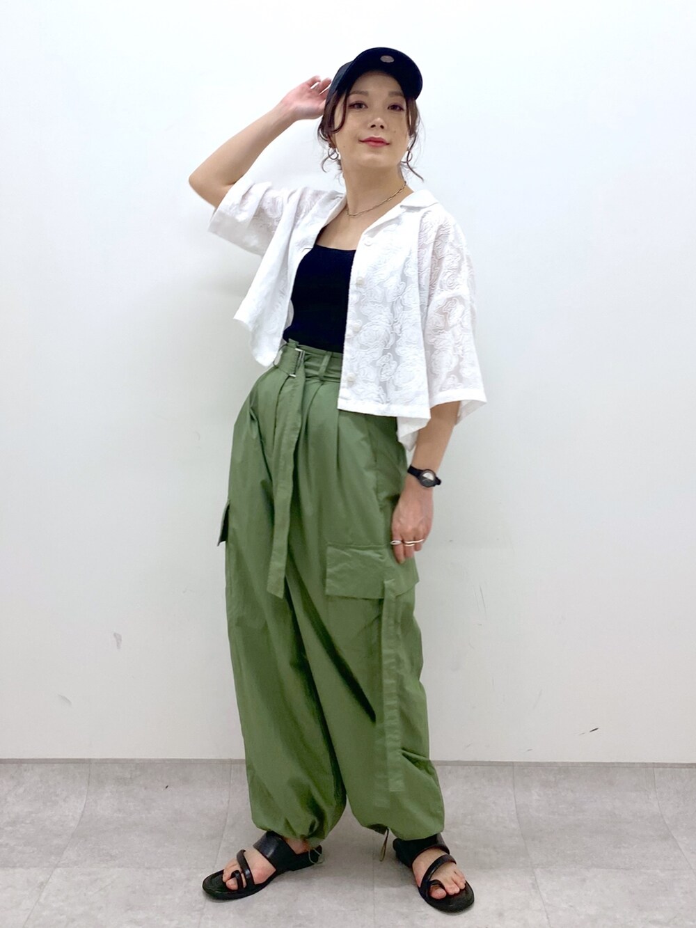 グリーン系のカーゴパンツ、ブラック系のサンダル、ブラック系のトップスを着用したレディースの夏コーディネートの6枚目の写真