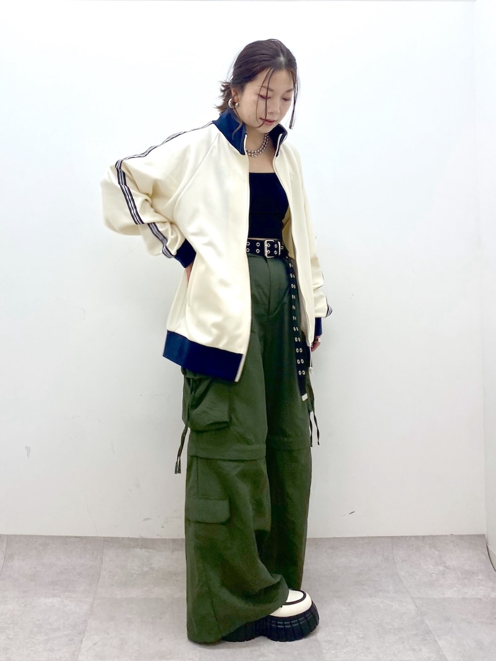 ブラック系のキャミソール、ホワイト系のセットアップ、グリーン系のカーゴパンツを着用したレディースの冬コーディネートの8枚目の写真