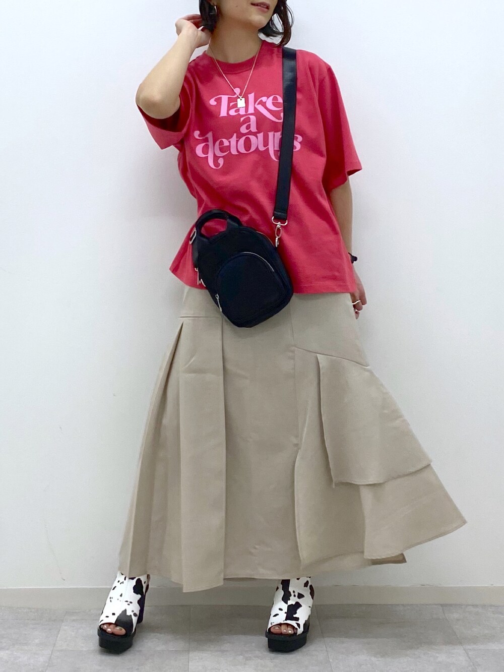 ベージュ系のスカート、ホワイト系のサンダル、ブラック系のショルダーバッグを着用したレディースの春コーディネートの5枚目の写真