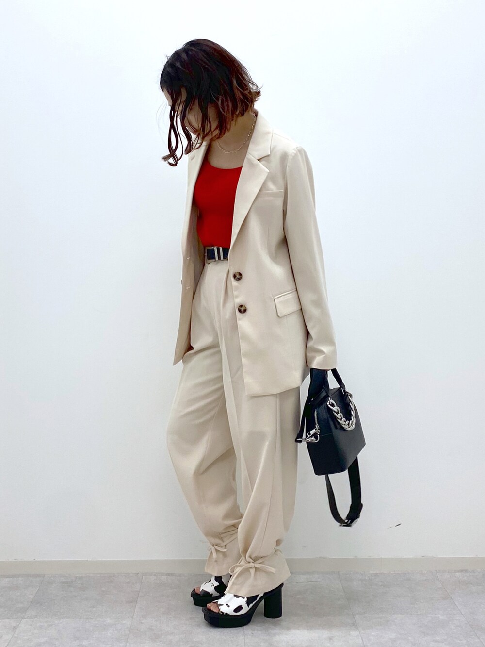 レッド系のタンクトップ、ホワイト系のその他パンツ、ブラック系のショルダーバッグを着用したレディースの春コーディネートの3枚目の写真