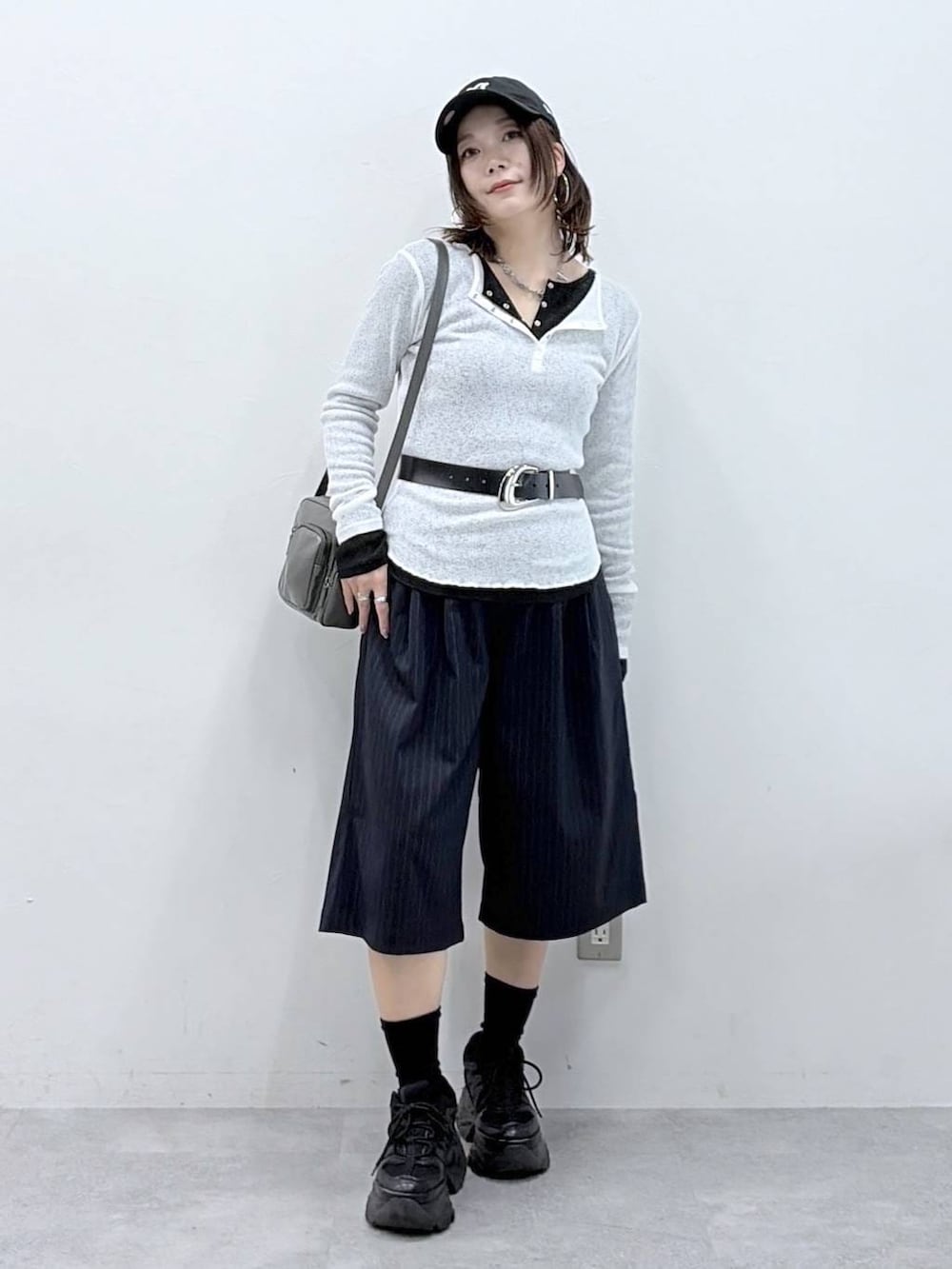 ブラック系のスニーカー、グレー系のショルダーバッグ、ブラック系のTシャツ/カットソーを着用したレディースの春コーディネートの4枚目の写真