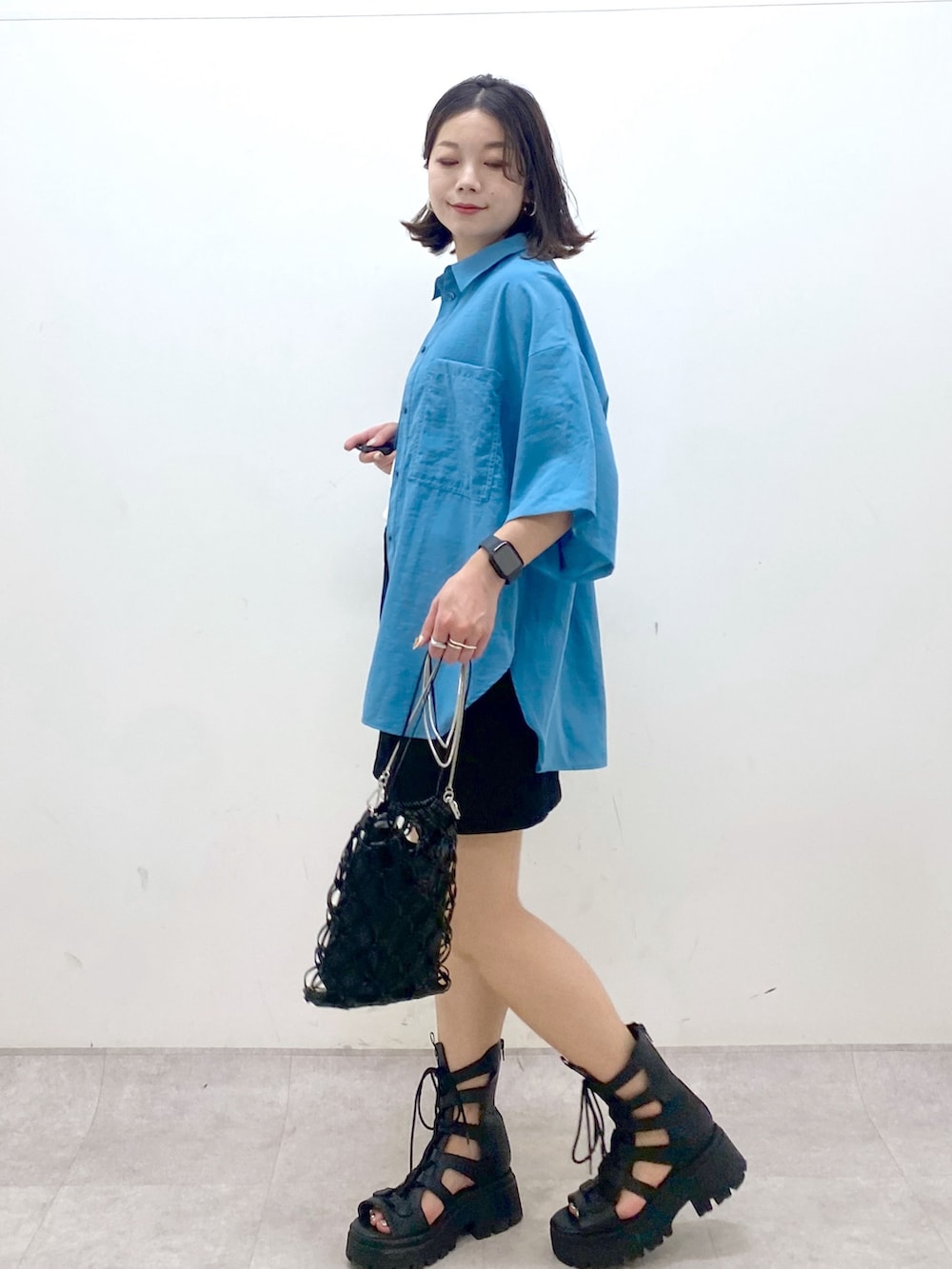 ブルー系のシャツ/ブラウス、ホワイト系のタンクトップ、ブラック系のスカートを着用したレディースの夏コーディネートの5枚目の写真