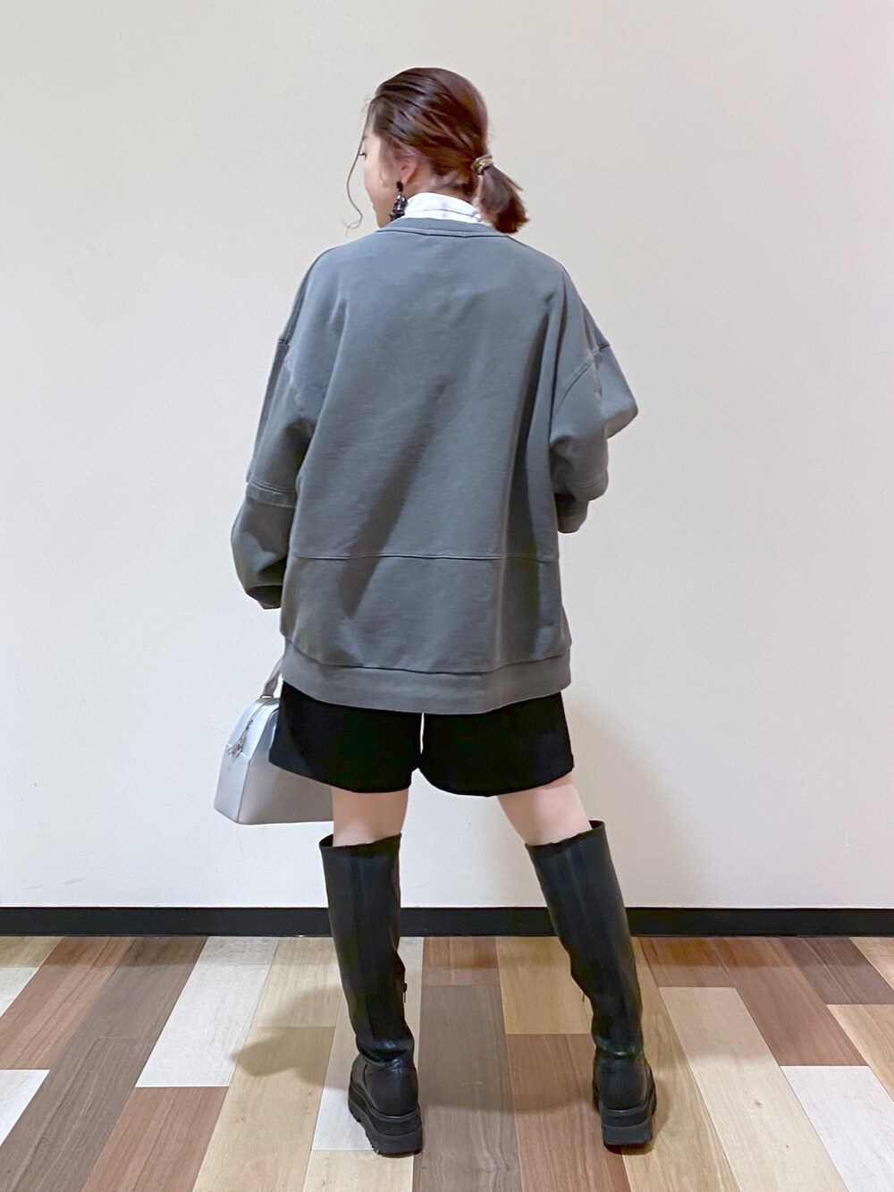 シルバー系のショルダーバッグ、ブラック系のブーツ、ブラック系のその他パンツを着用したレディースの冬コーディネートの4枚目の写真