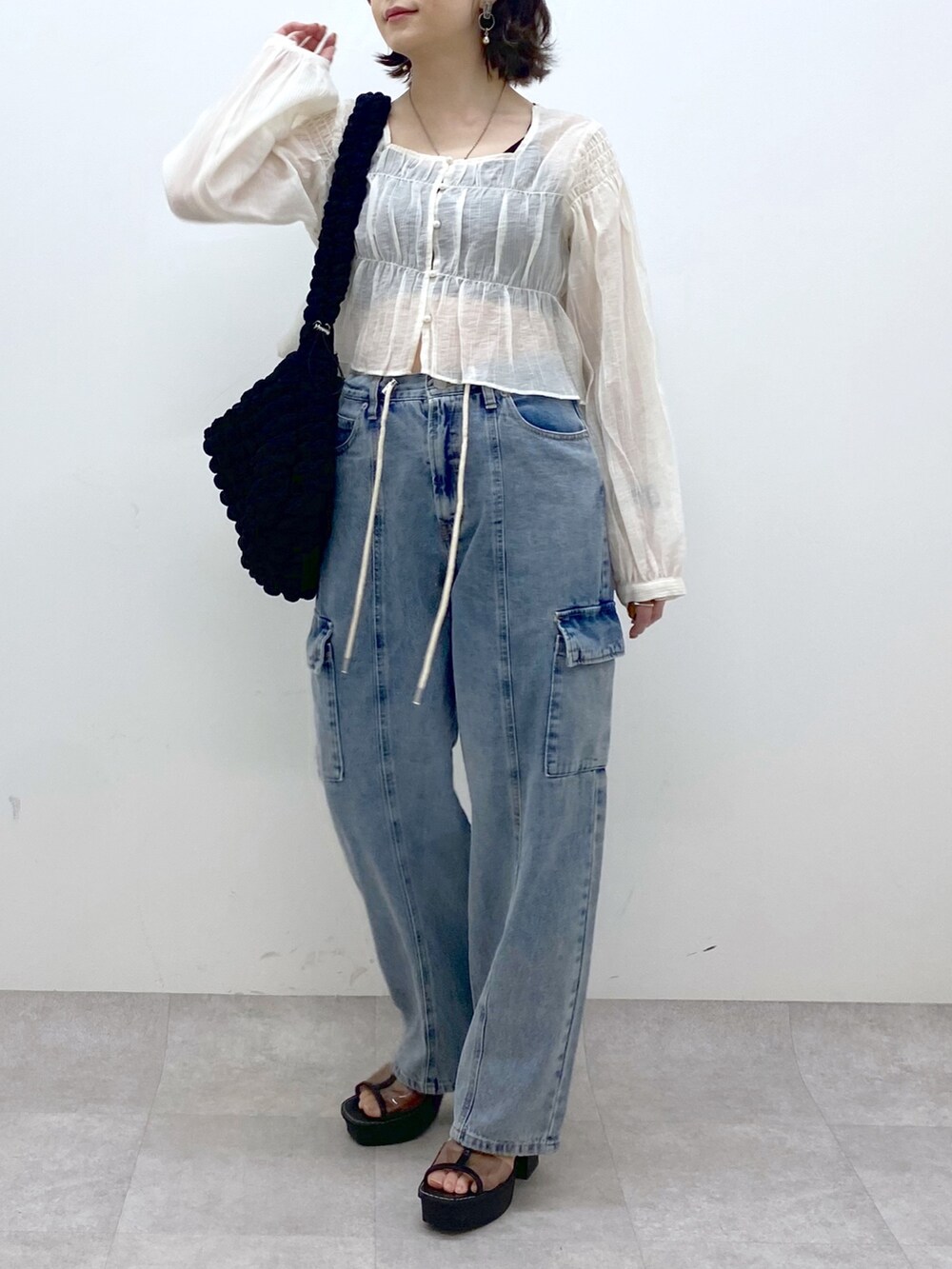 ホワイト系のシャツ/ブラウス、ブルー系のデニムパンツ、ブラック系のバッグを着用したレディースの春コーディネートの5枚目の写真