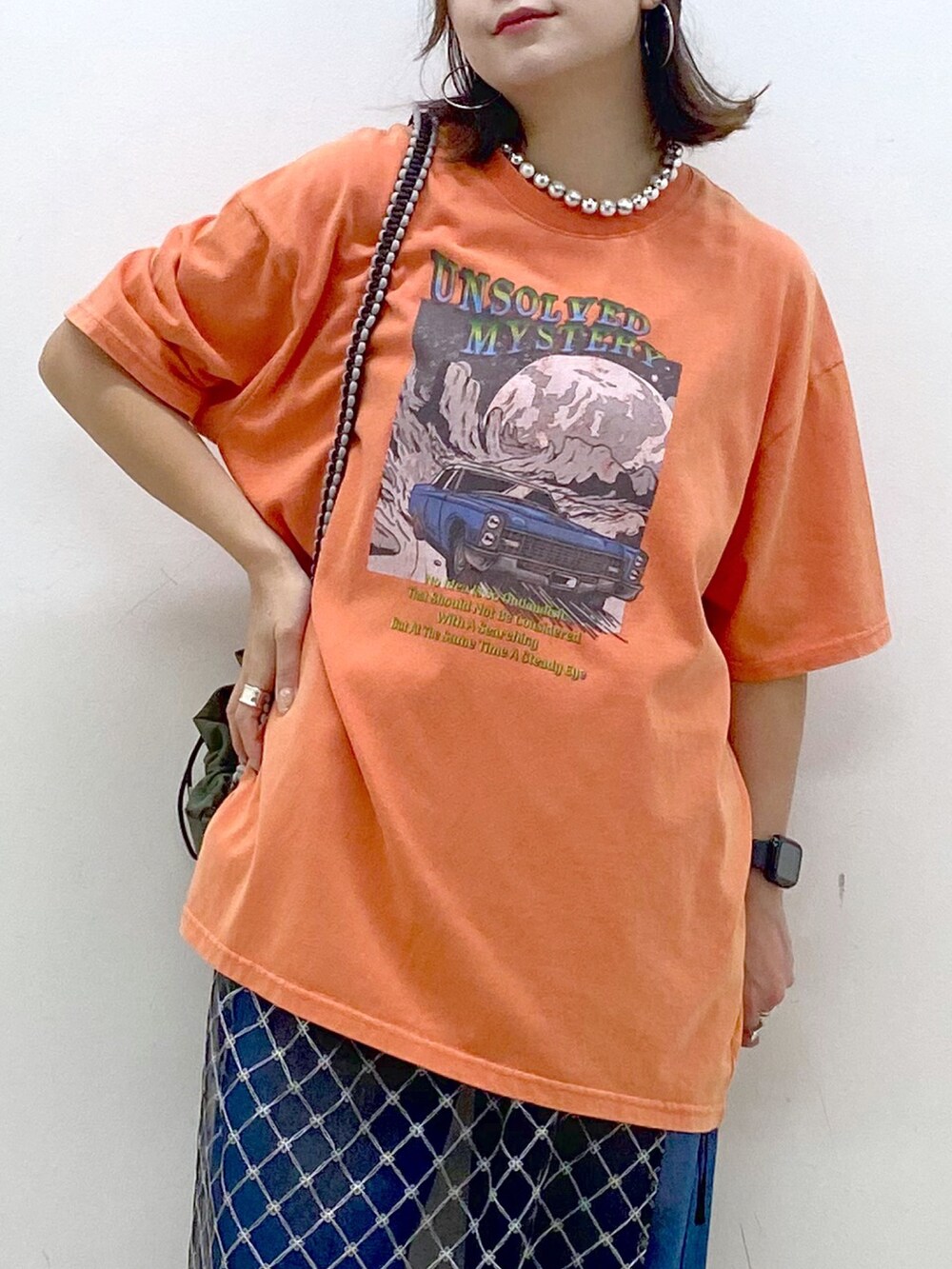 ピンク系のTシャツ/カットソー、ブルー系のデニムパンツ、ホワイト系のスニーカーを着用したレディースの夏コーディネートの2枚目の写真