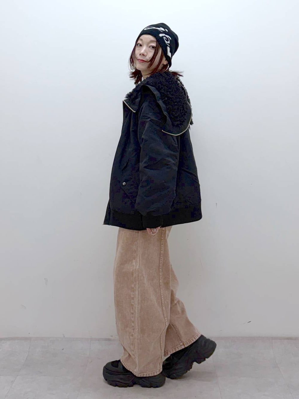 ブラック系のブーツ、ブラック系のボストンバッグ、ブラック系のブルゾンを着用したレディースの冬コーディネートの6枚目の写真