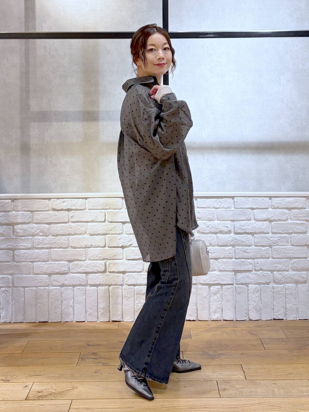 ブルー系のデニムパンツ、ホワイト系のボストンバッグ、ブラウン系のサンダルを着用したレディースの春コーディネートの6枚目の写真