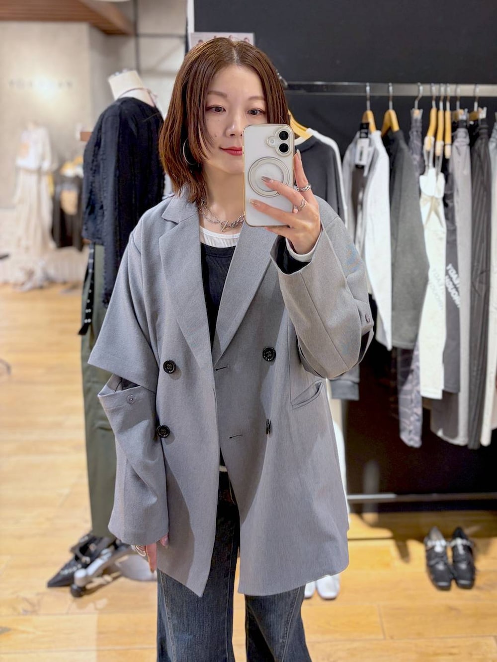 ブルー系のデニムパンツ、グレー系のテーラードジャケット、ブラック系のTシャツ/カットソーを着用したレディースの春コーディネートの6枚目の写真