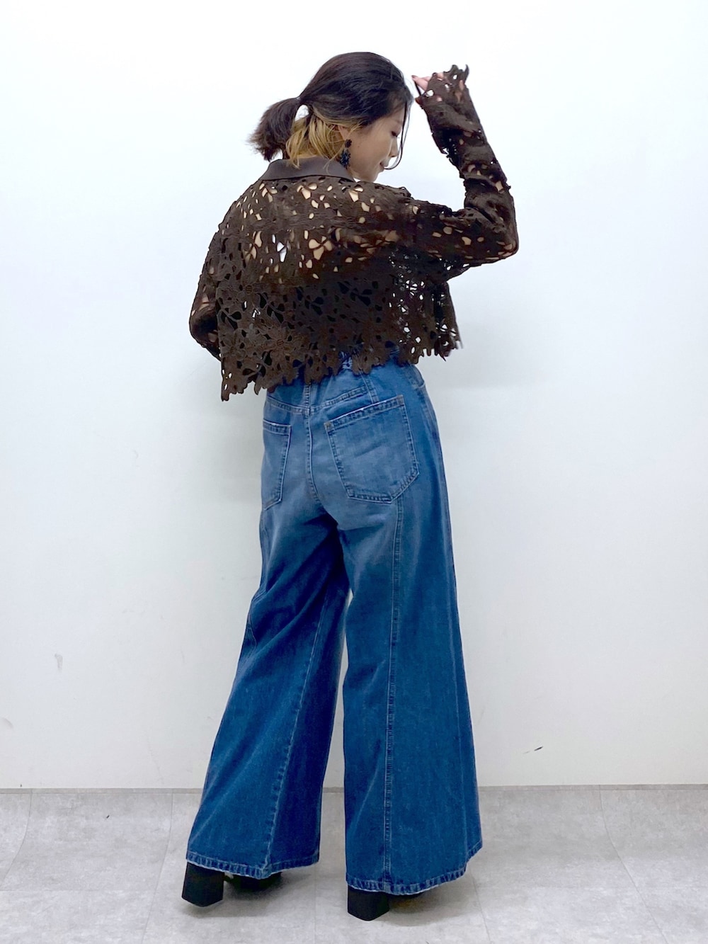 ブルー系のデニムパンツ、ブラウン系のカーディガン/ボレロ、ブラック系のキャミソールを着用したレディースの夏コーディネートの6枚目の写真